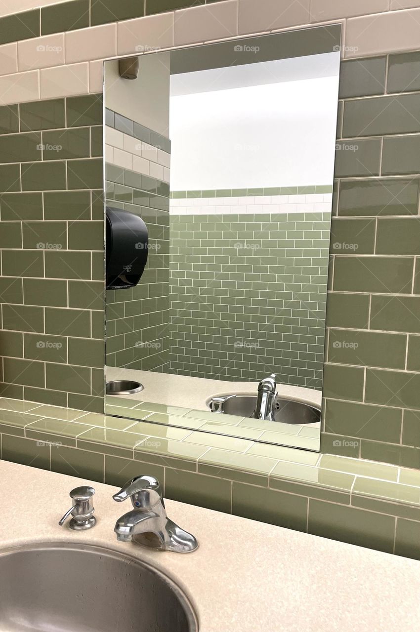 Public restrooms in a building, public restroom sinks and mirror, reflection of a public restroom, portraits of a bathroom 