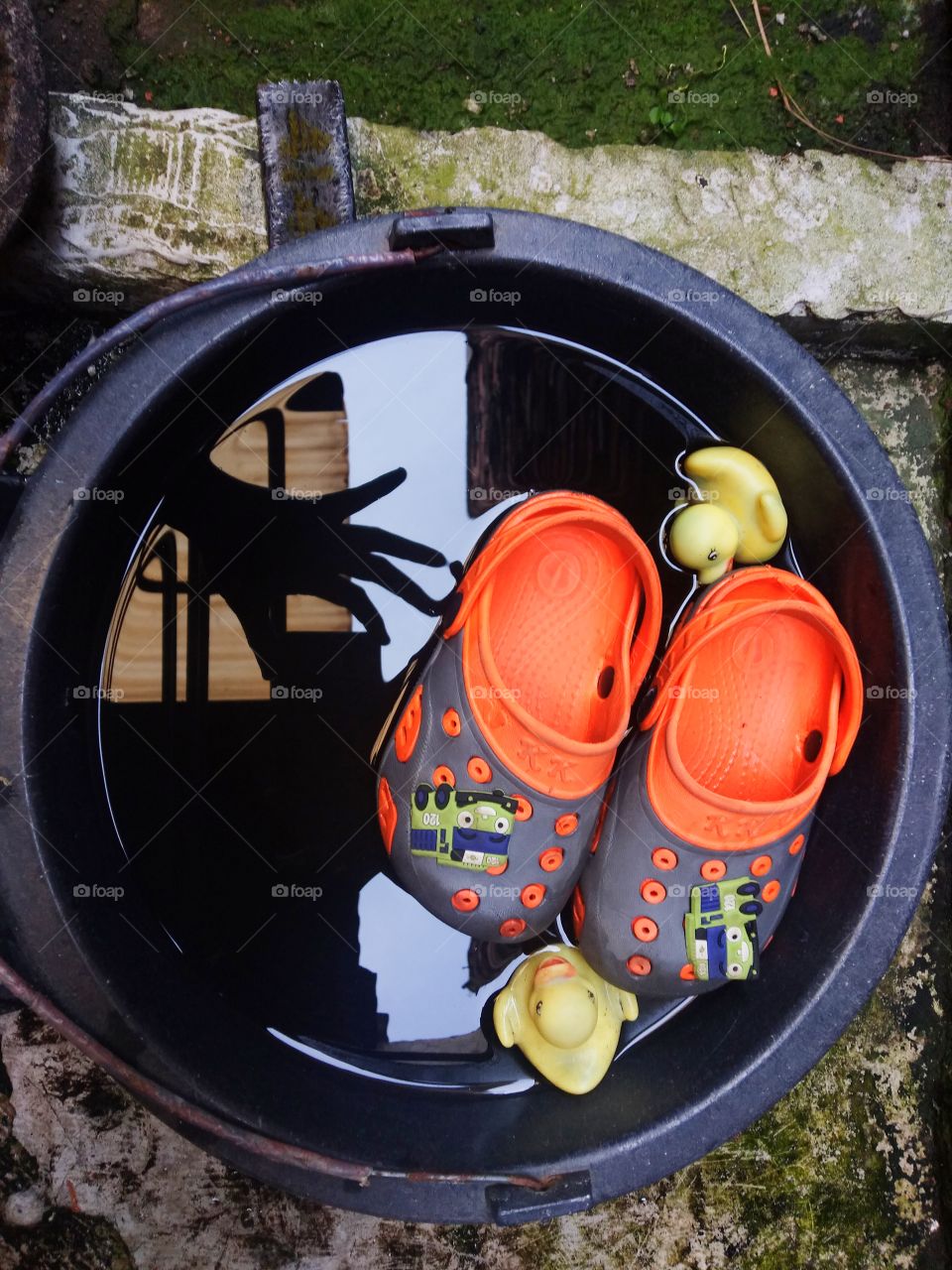 kid slippers and duck toys in the bucket