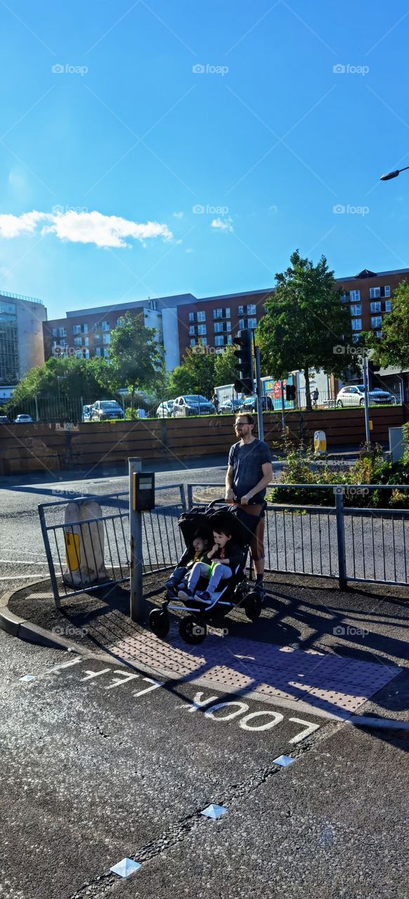 padre con su hijo esperando la señal del semáforo para cruzar la calle