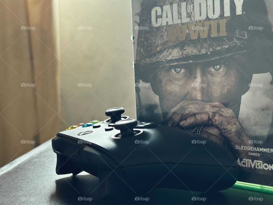 Call of duty video game box behind of a Xbox controller with natural light at the background.