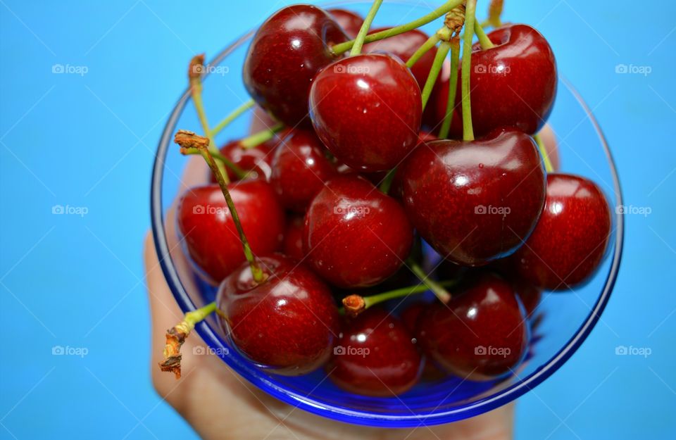 red cherry tasty summer food in hand top view table blue background