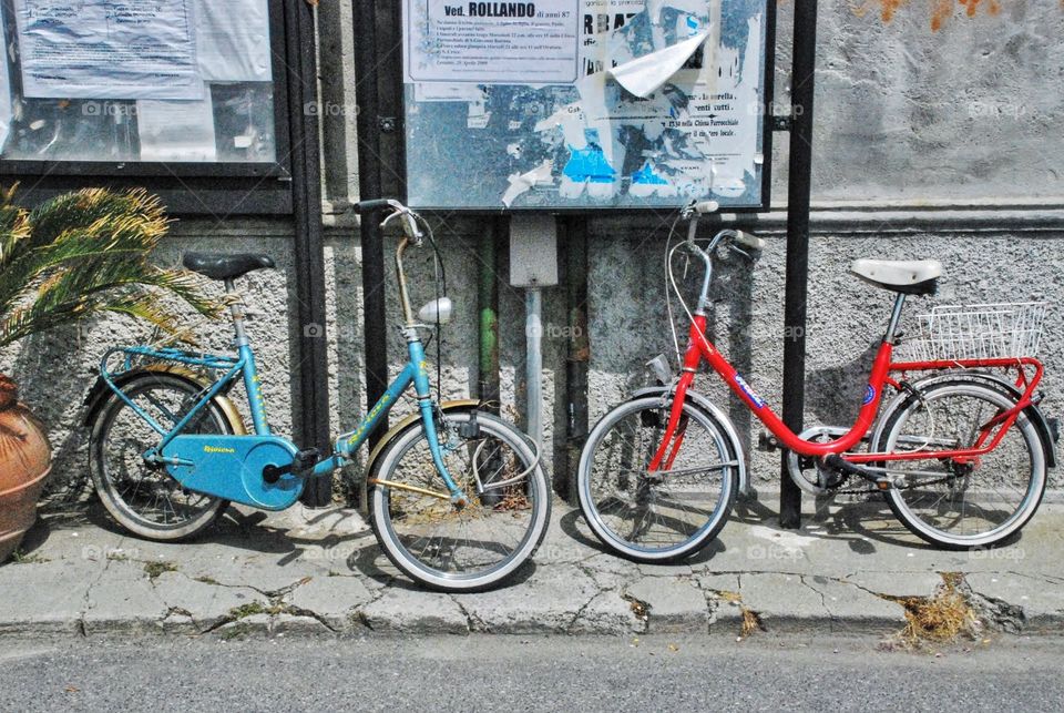 Red, white and bike. A pair of bikes waiting for their owners against a wall