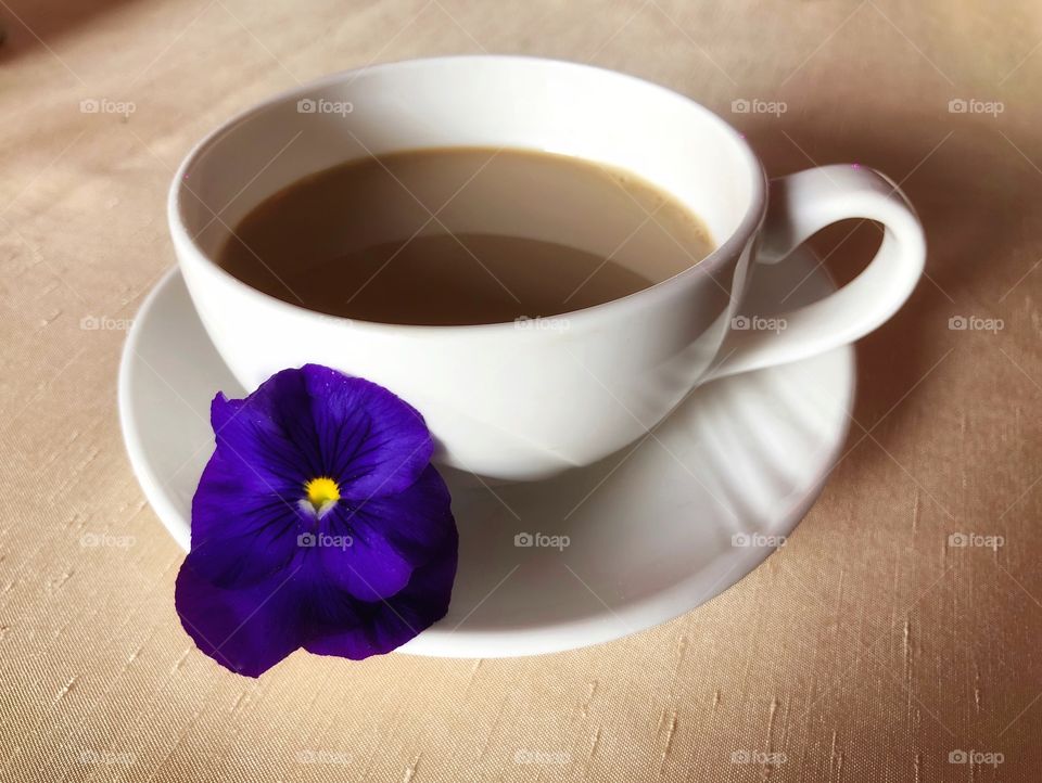 Simple cup of coffee with a purple flower
