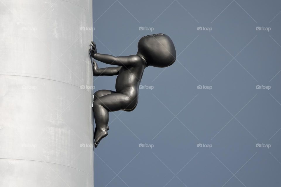 Sculpture of a bronze faceless baby crawling the Zizkov Television Tower. Designed by Czech Artist David Cerny, these scultpure is called miminka.