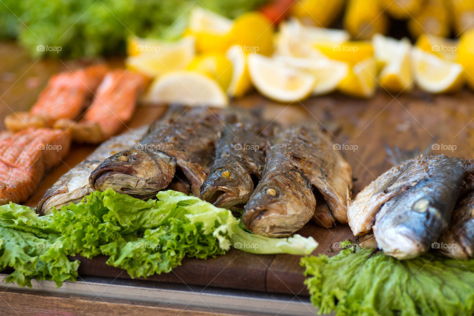 Grilled fish served with lemon and lettuce