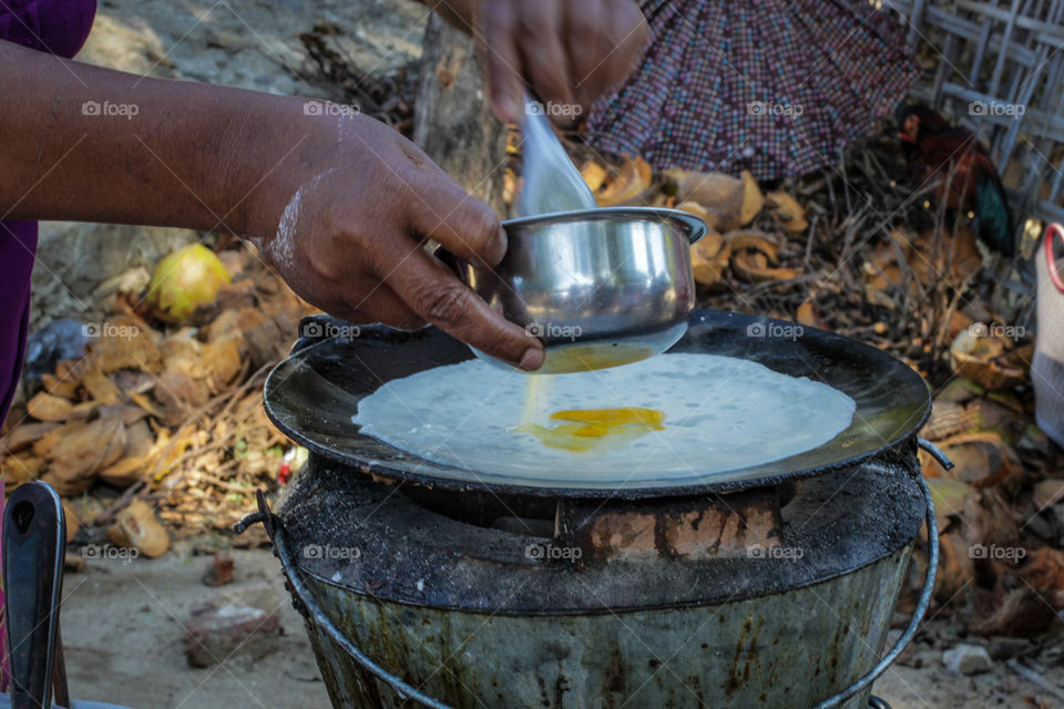 In front on one of the Burmese temples this woman found a shady spot and was making coconut stuffed sweet pancakes