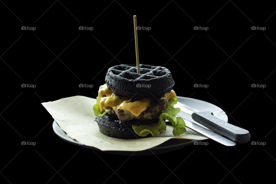 Isolated Hamburger black pork on a black background with clipping path.