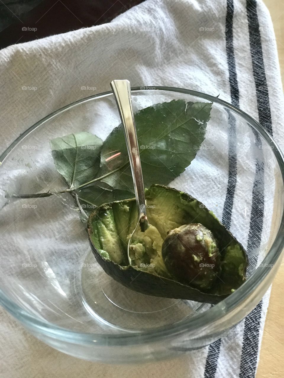 A delicious avocado fruit in a glass bowl with a spoon. -Let’s eat ! 
