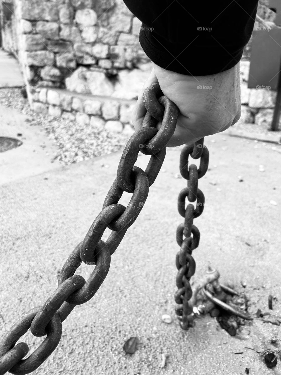 Black and white photo of a man holding a chain.