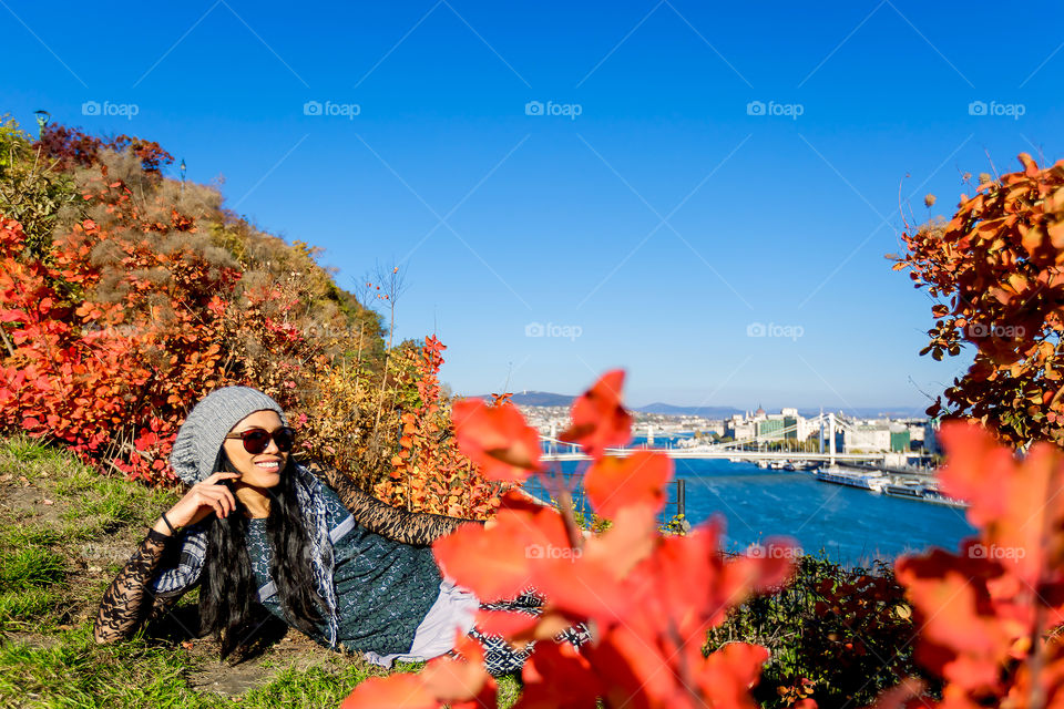 Woman on grass near river in the city
