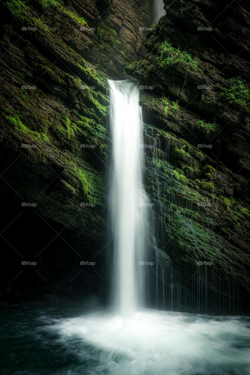 A mystical waterfall surrounded by moss