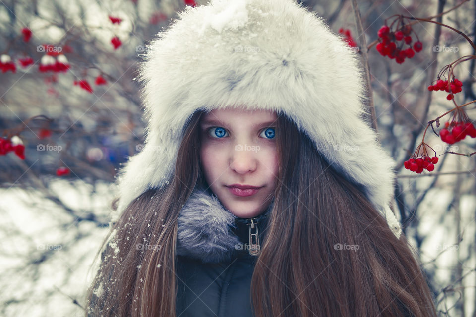 Winter portrait of a girl in snowy winter hat