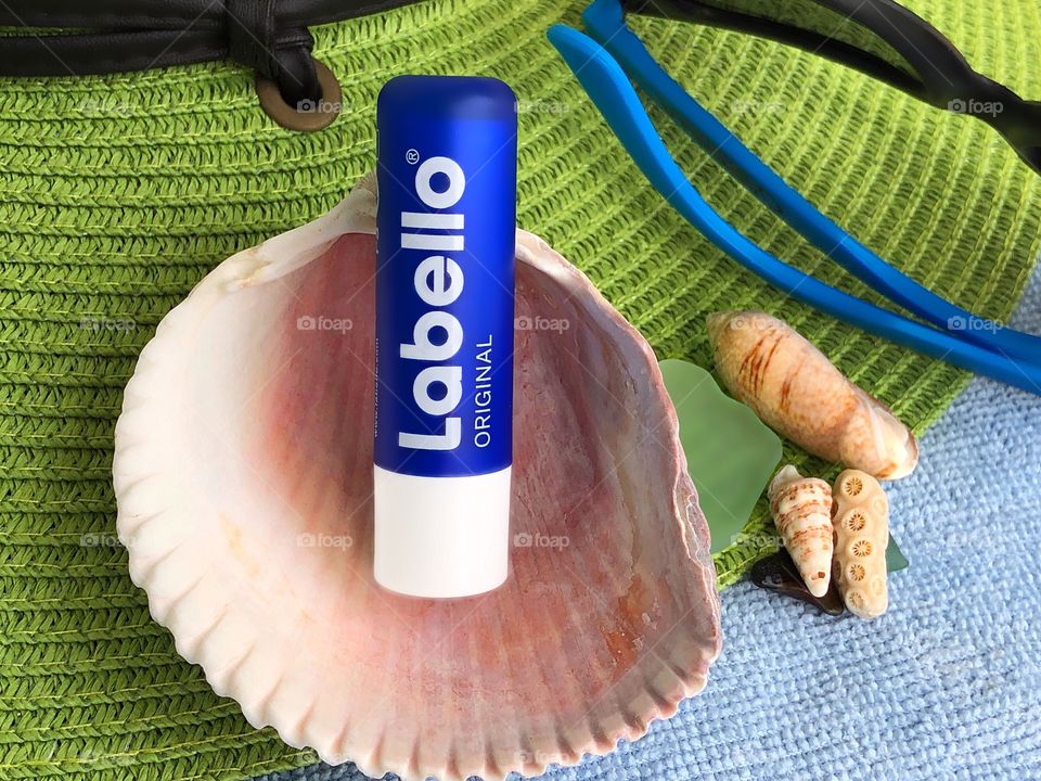 Labello lip balm flat lay with sea shells.