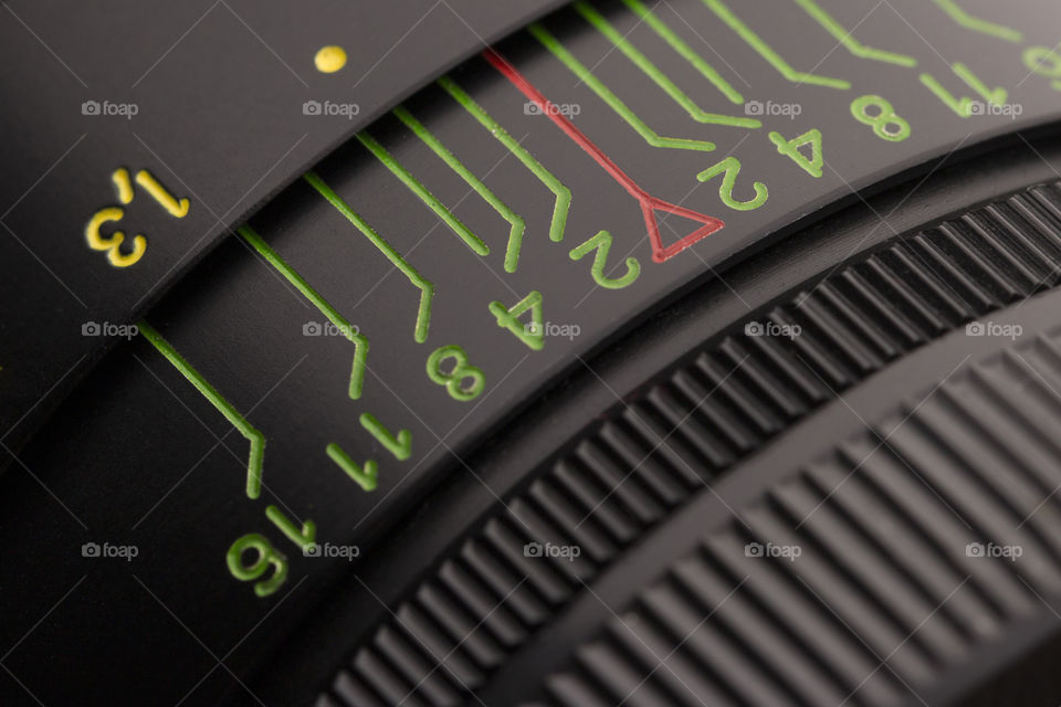 Close up of aperture ring of camera lens and depth of field scale with index. Vintage camera lens close-up.