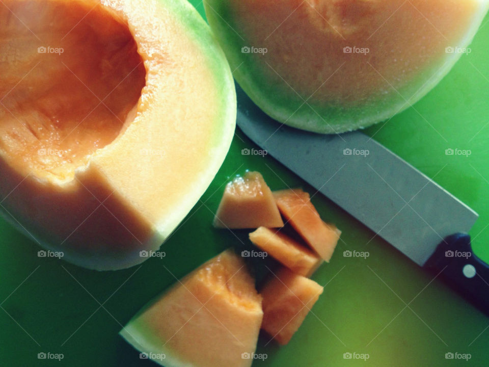 Slicing an orange-fleshed honeydew melon