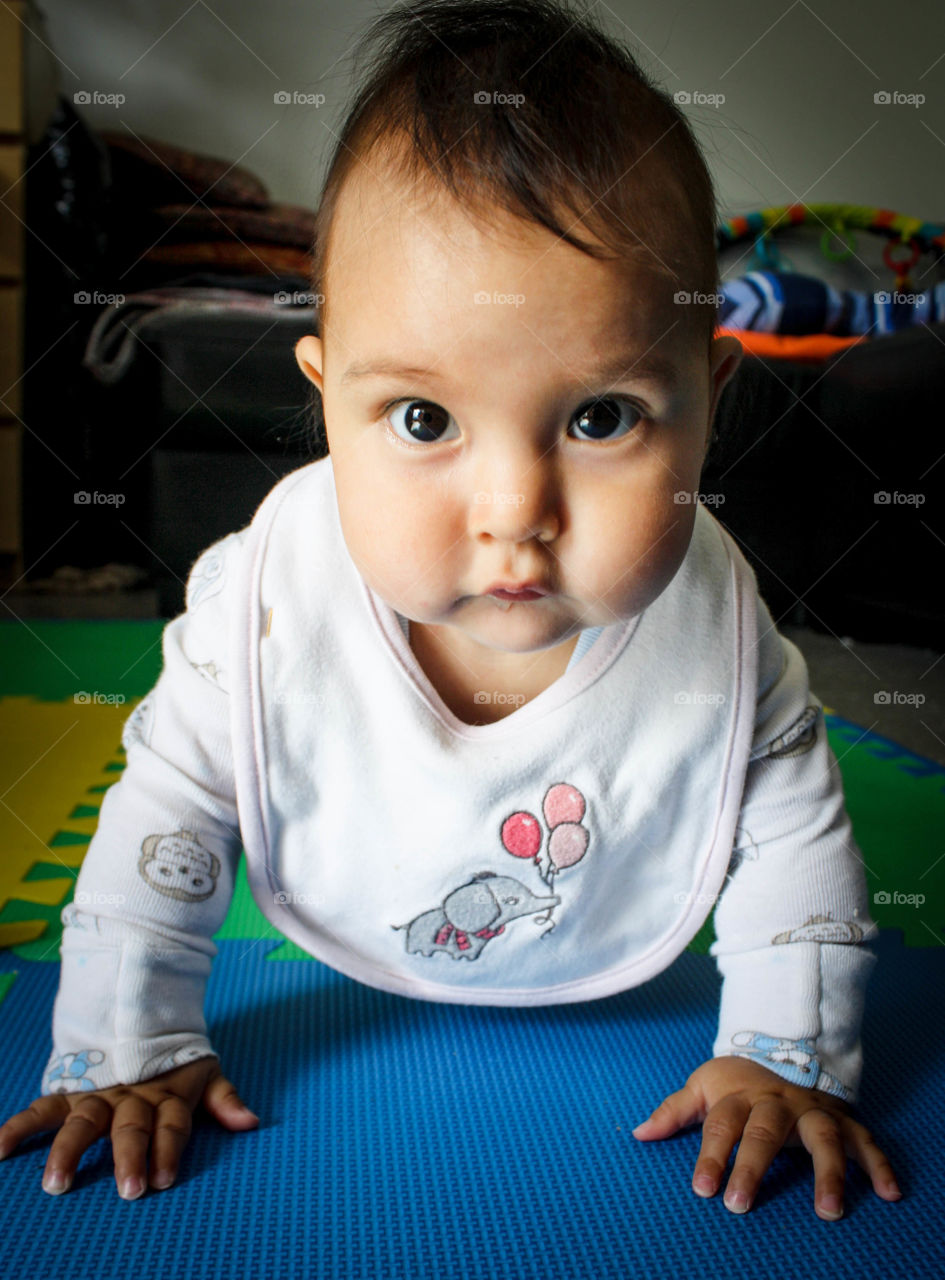 Cute baby with big eyes is crawling around the house