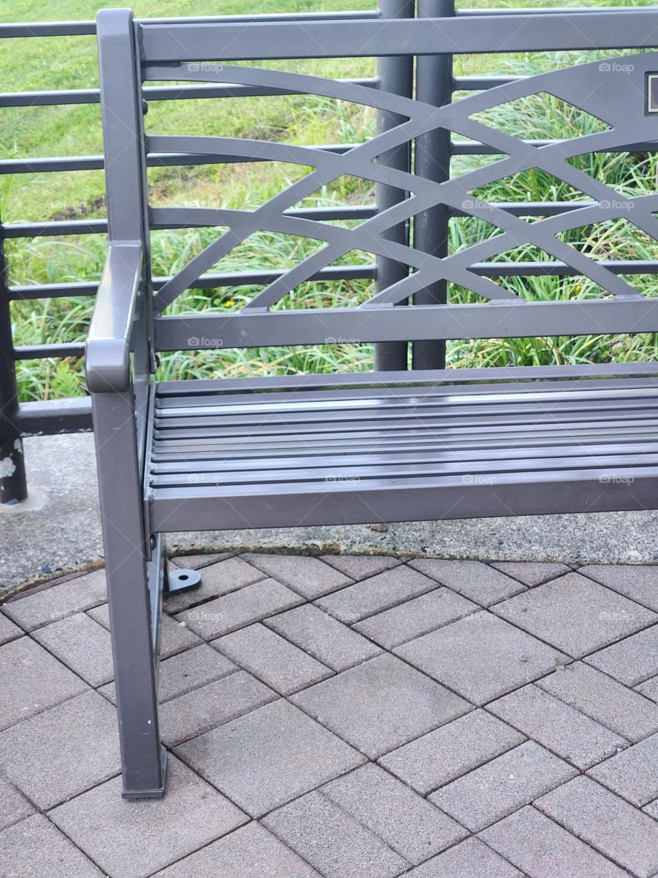 gray ornate park bench on brick pattern