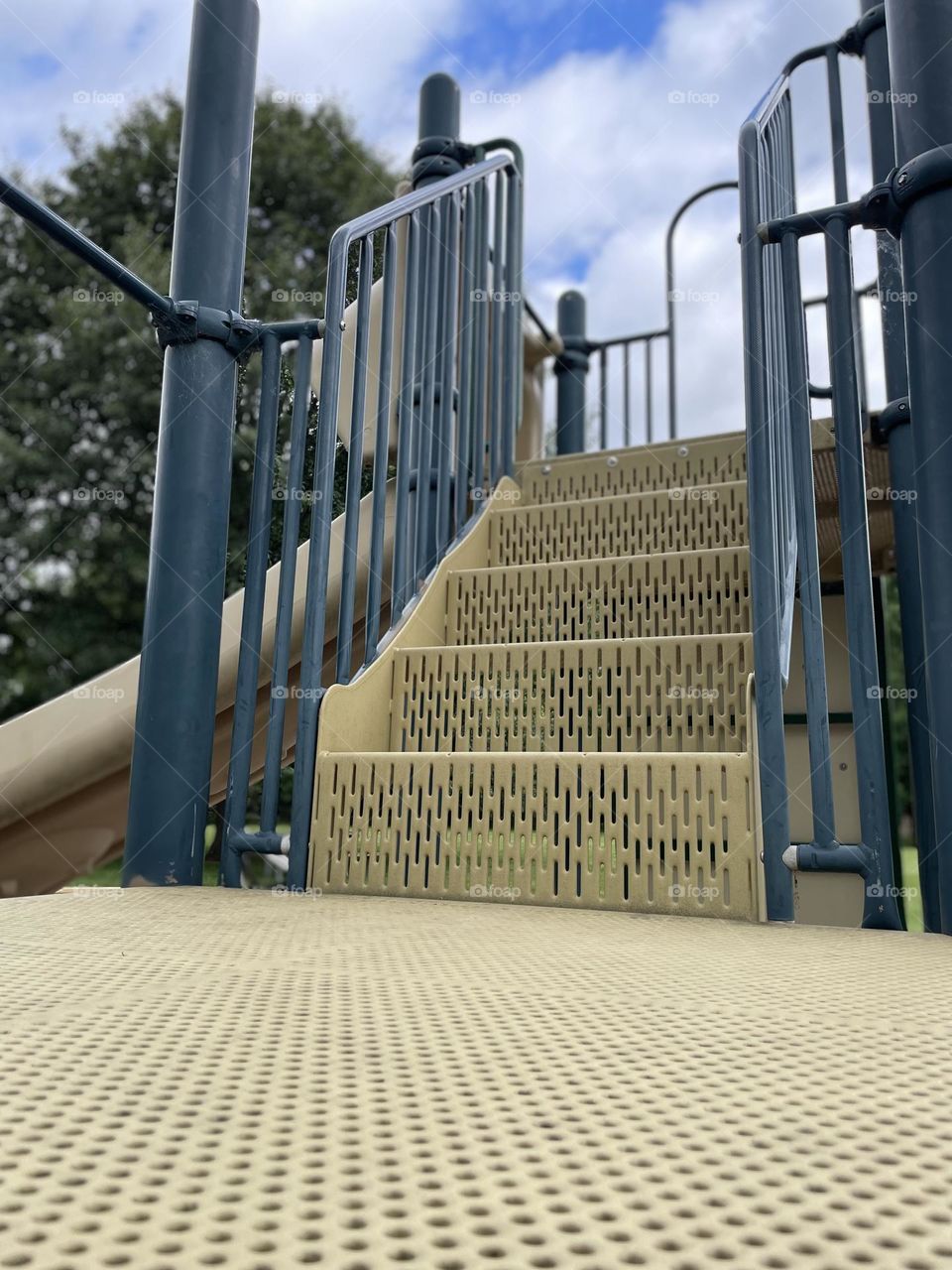 Climbing on the playground, stairs to the slide, playing on playground equipment, ready to slide in the park 