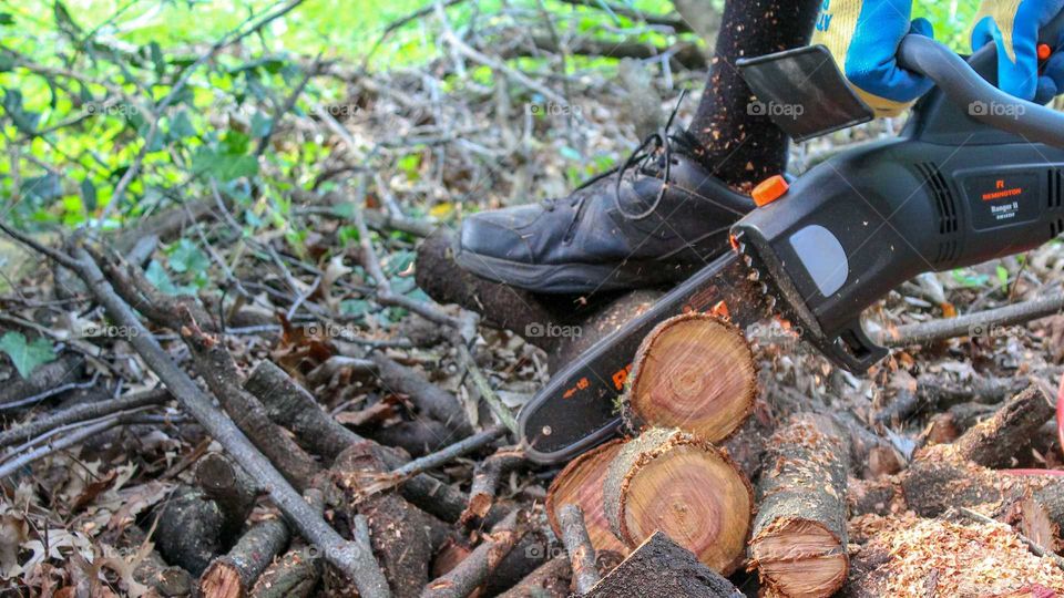 Cutting logs with a Remington electric chainsaw