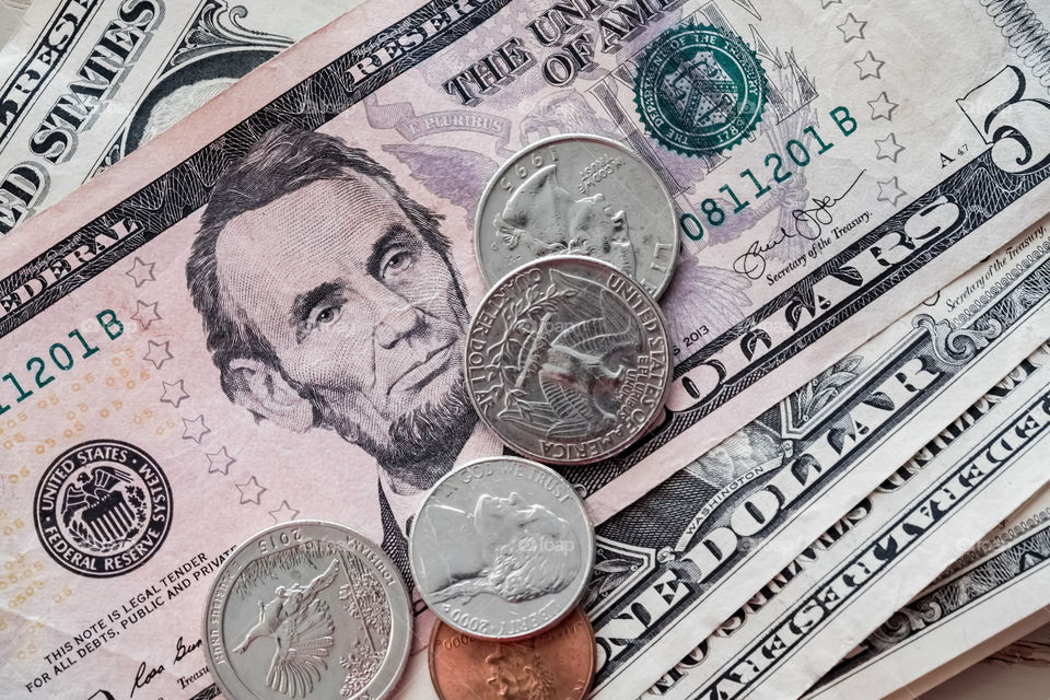 Coins and notes of The United States of America (U.S.A.) heaped together. A closeup view.