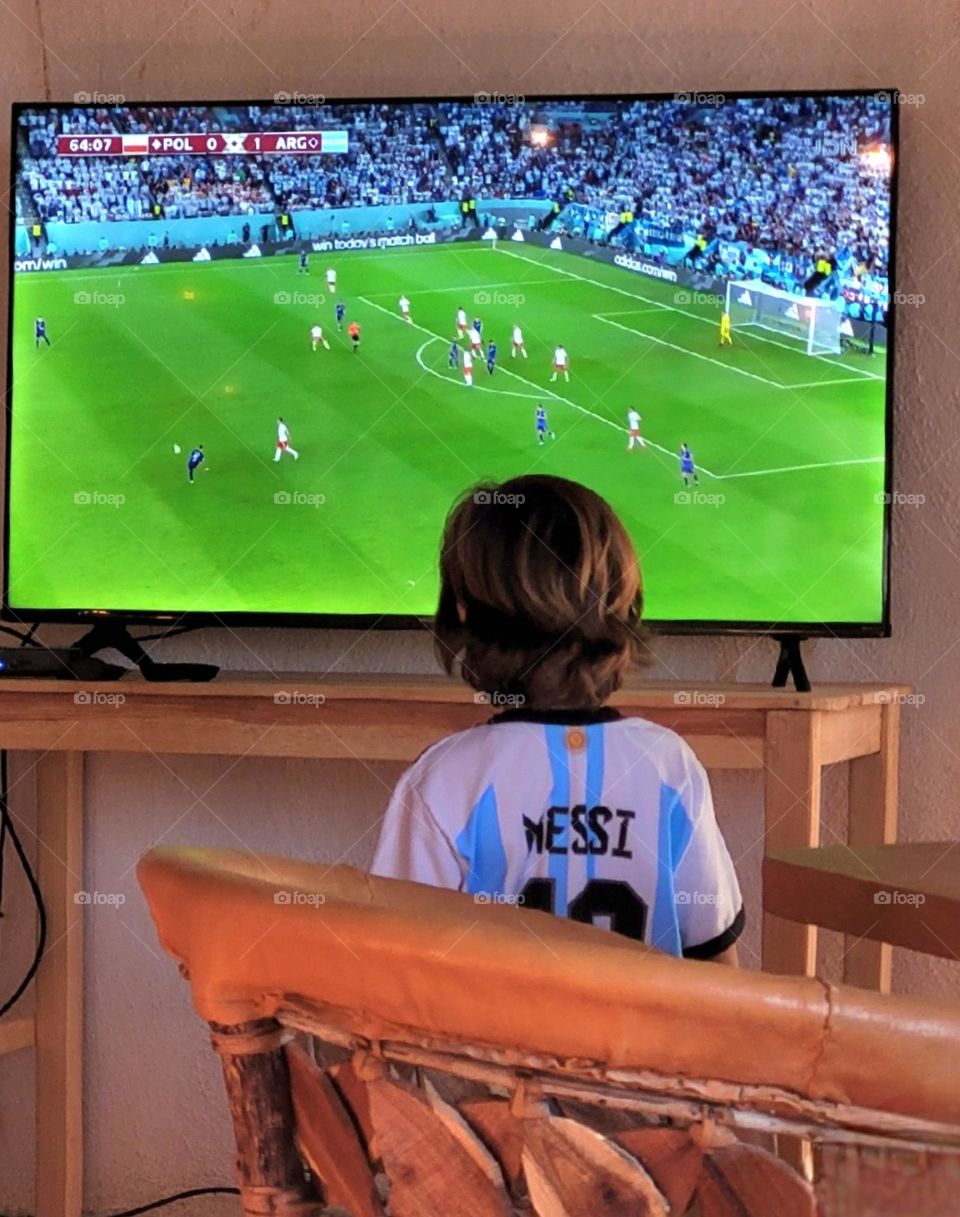 niño mirando partido de fútbol