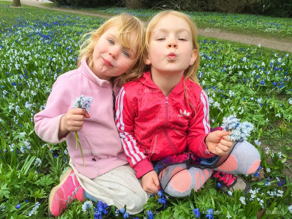 Two sisters posing for a spring picture in a park in Lund Sweden.
