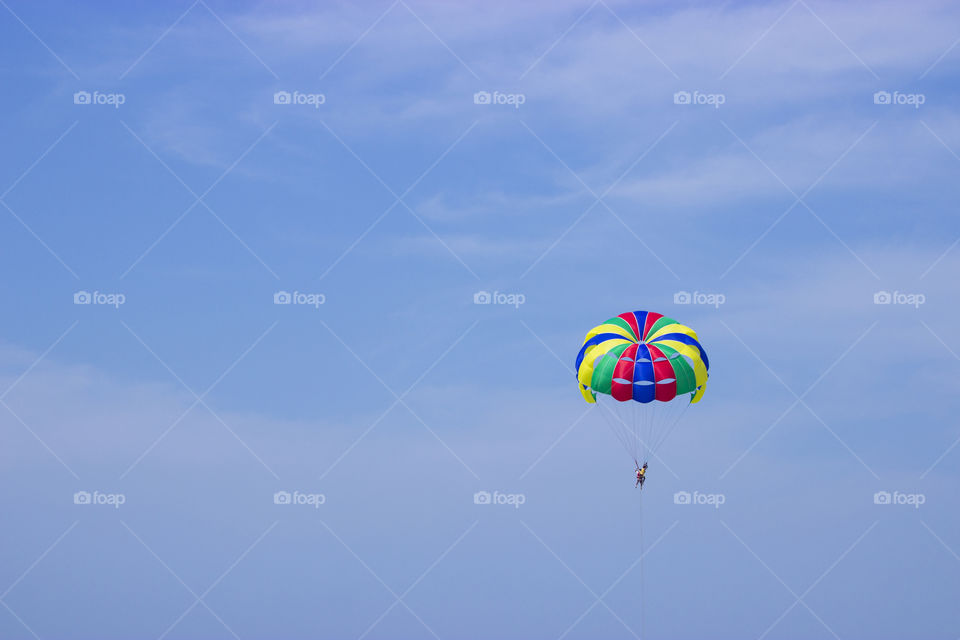 Man having fun while parasailing in the cloudy sky