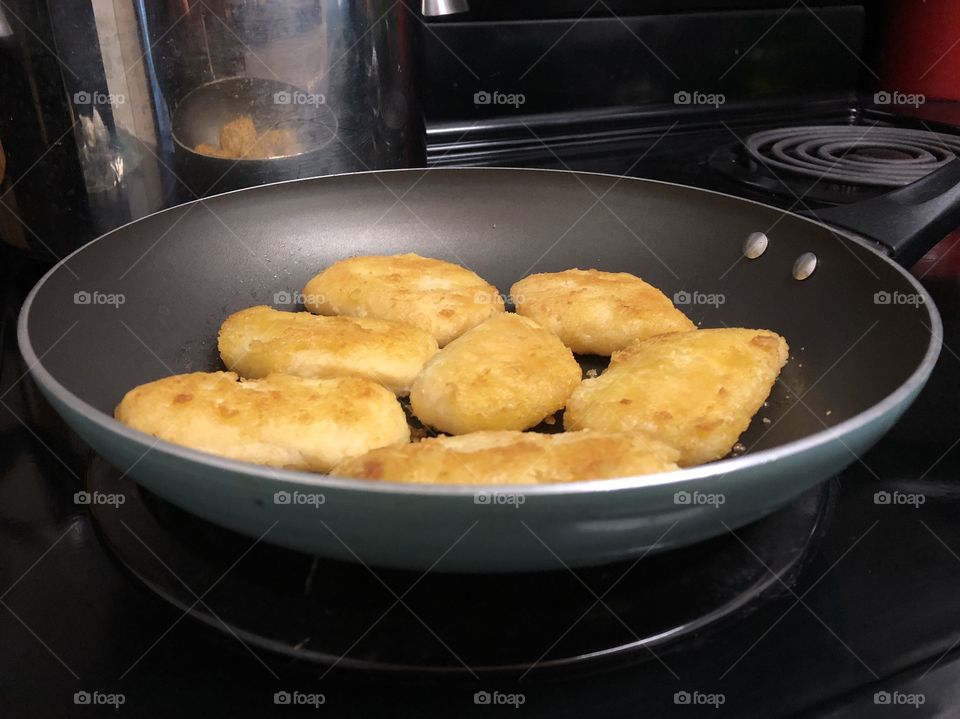 Frying battered halibut in a pan.