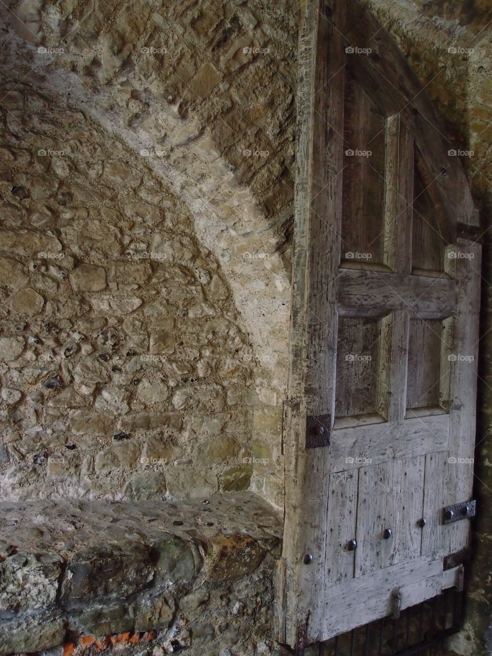 A worn wooden door in a corridor attached to an old stone building in Dover England. 