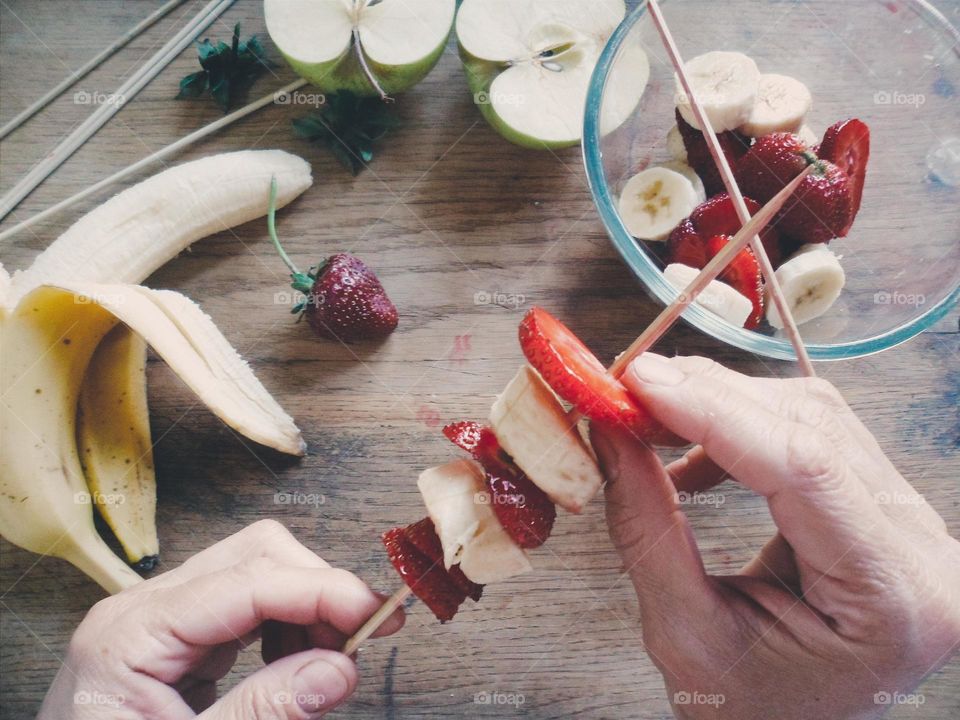 Close-up of a hands make a fruit salad