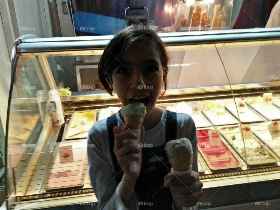 A child eats two ice creames.