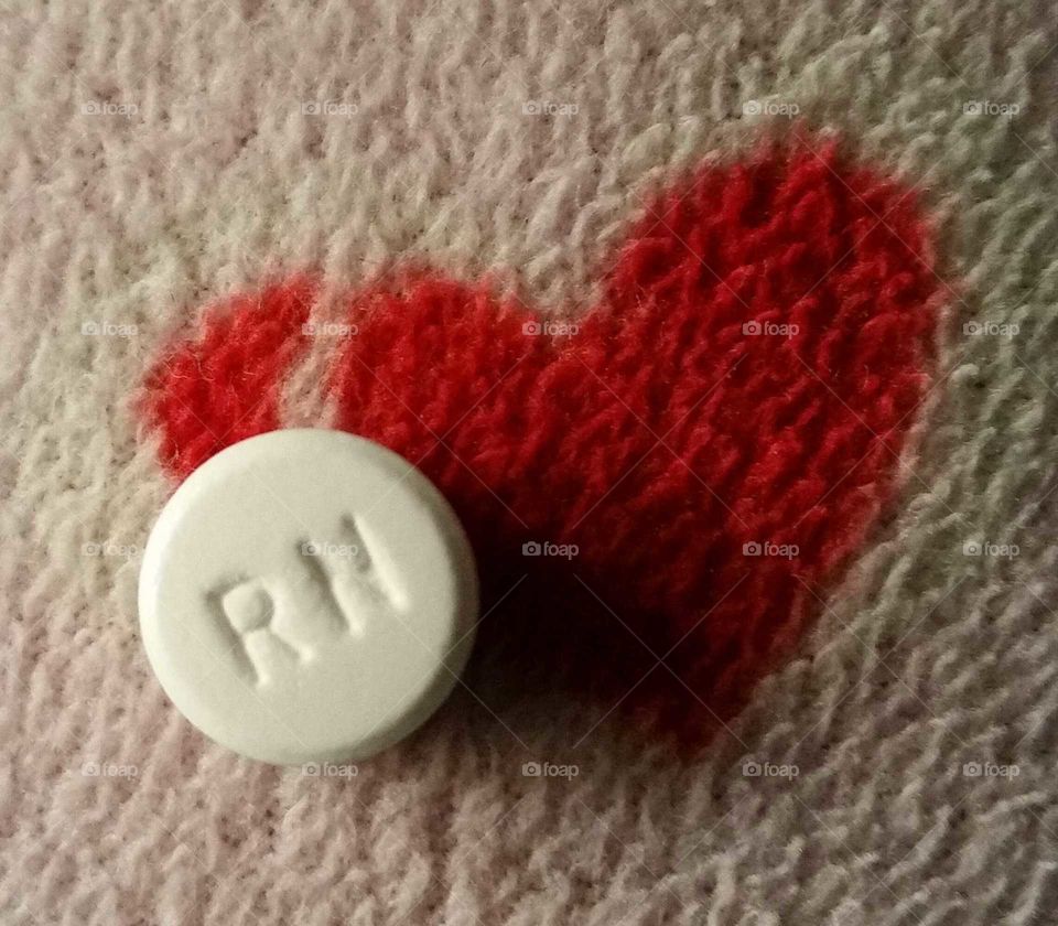 love for the nursing profession,  RN stamped on a pill, pill resting on a heart
