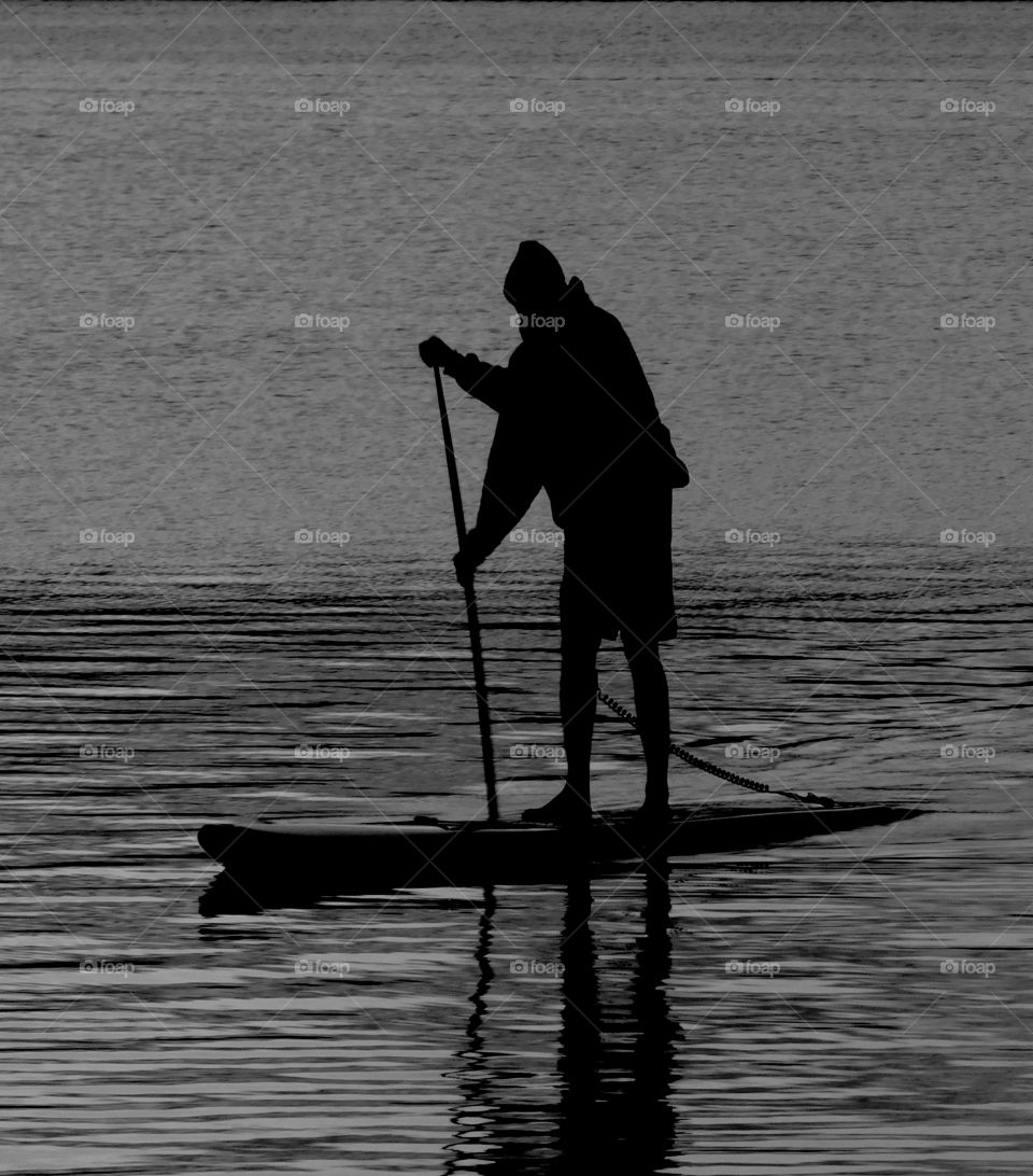 Silhouette of person doing paddle boarding