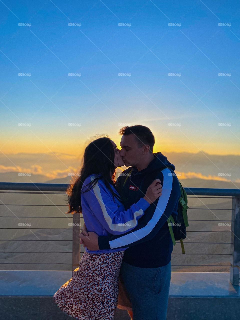 Kiss at sunset against the background of mountains