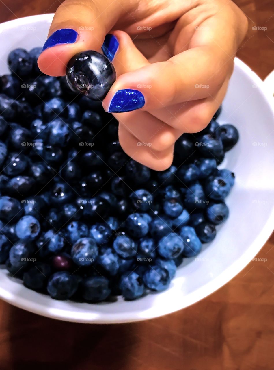 Close-up of hand holding blueberry