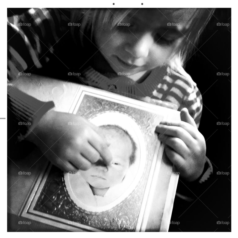 Child looks at vintage photo