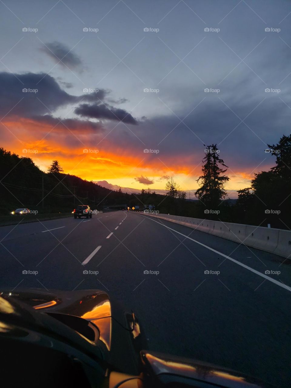 Gorgeous orange and red sunset driving home on the road.