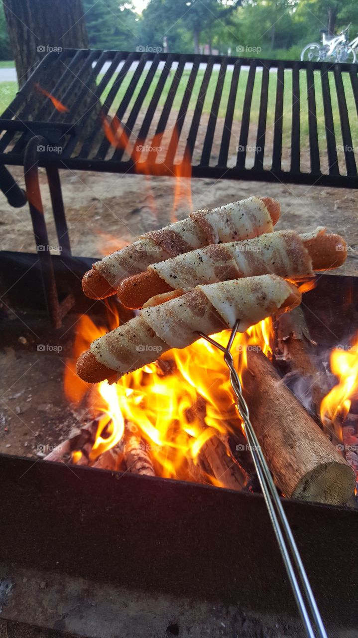 Bacon wrapped hotdogs on the campfire
