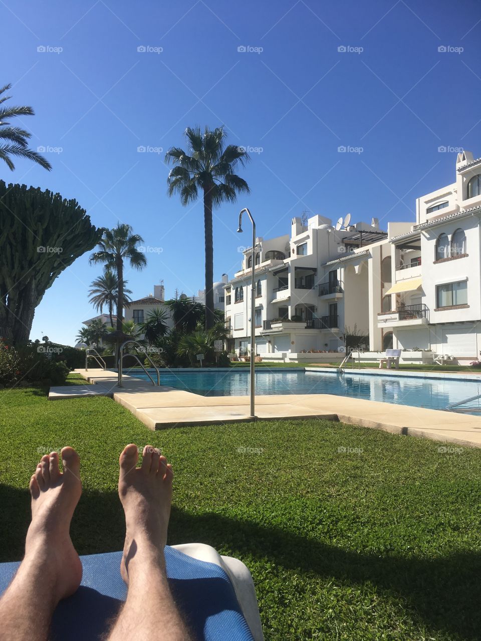 ‘2 feet from the pool...’ Time to relax. The crisp blue sky. The palm trees. The pool. This is Spain. 
