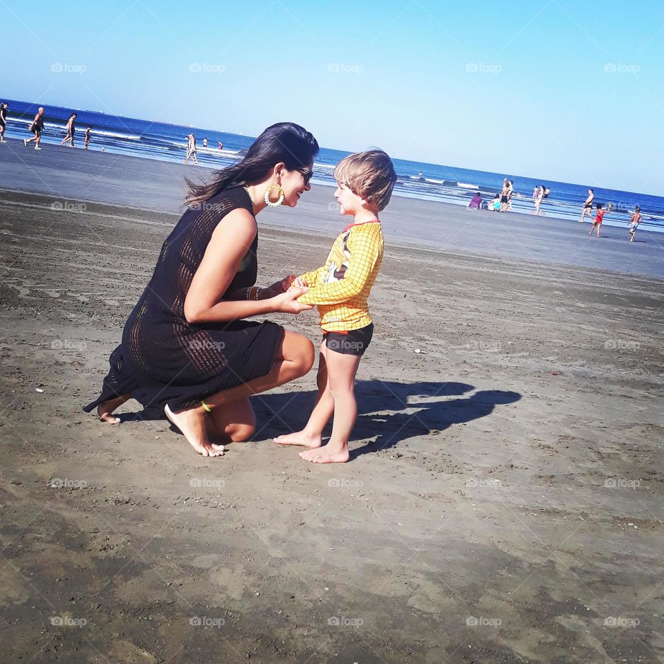 mother and son looking at each other on the beach so much love