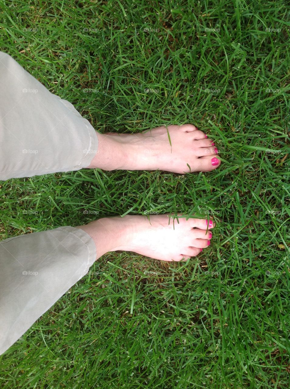 Feet in the green grass.