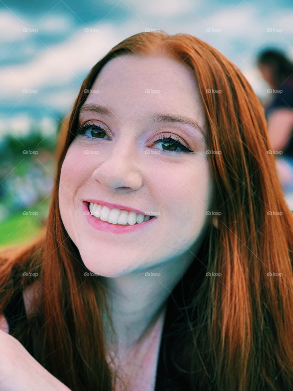 Beautiful up close portrait of a model with red hair at a music festival in the United States having fun and smiling