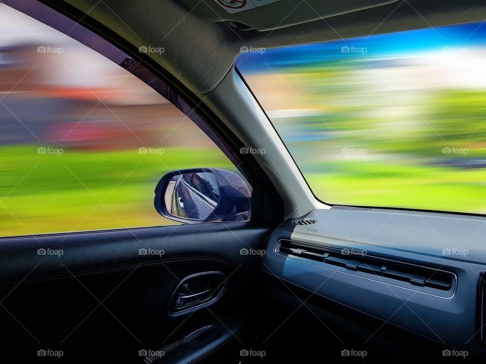 Driving a car, view inside car, from left side door glass and front of the car, to left of the driver, only the color display looks blurry, full of beutifu; color,