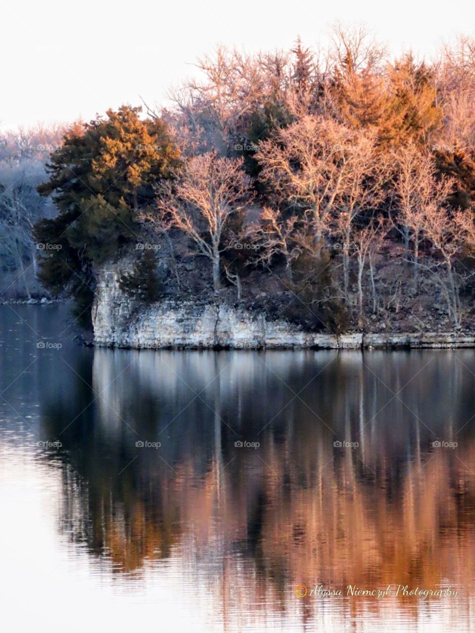 Stunning reflection right at dusk. The tips of the trees kissed by the sunlight.