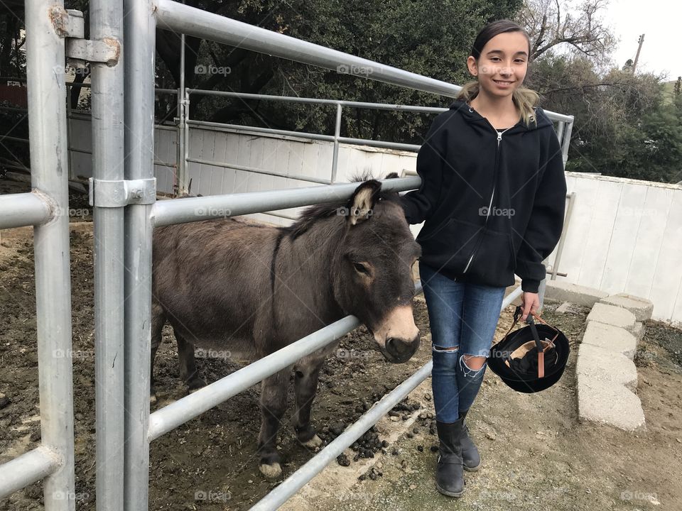 My daughter, Julia, before horseback riding lessons, she likes to pet the cute donkey. 