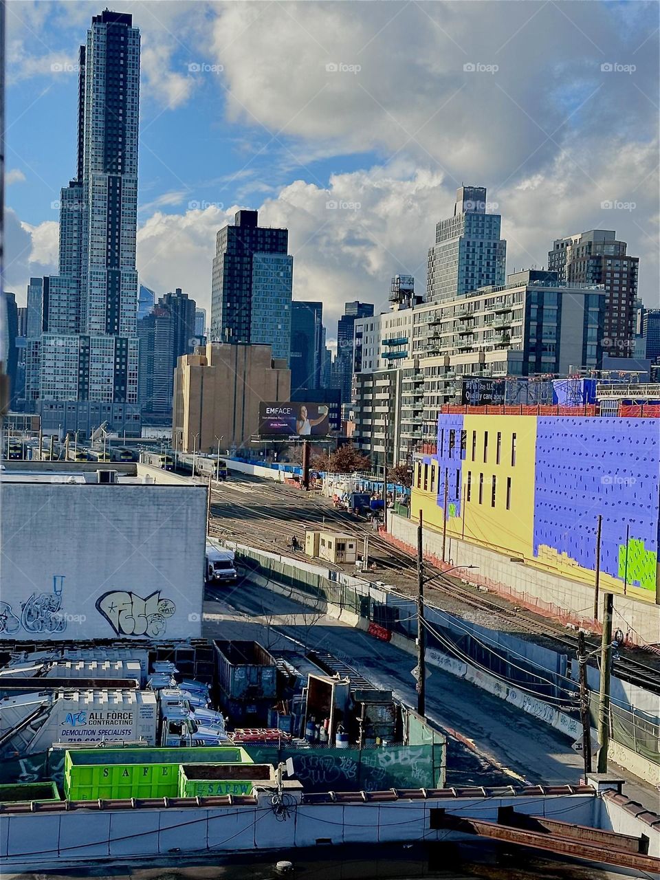 This is the view from the top of the red metal staircase of the “Pulaski Bridge” at “Newtown Creek” in LIC, Queens overlooking the “Long Island City” train tracks, LIC and “Manhattan”. 2023. Hypnotic Productions