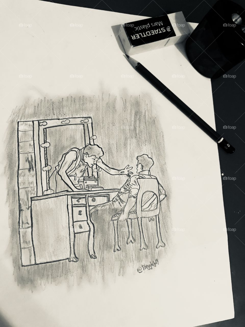 A black and white drawing of a poignant dance scene. Characters are surrounded by an ancient mirror. One is grabbing at the other who’s sitting on a chair, lying back. There’s also an eraser, a sharpener and a pencil.
