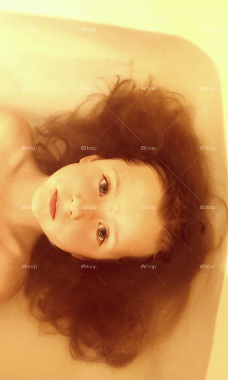 High angle view of a girl lying on bath tub