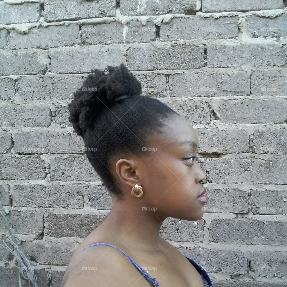 Natural hair tied in a bun/puff.