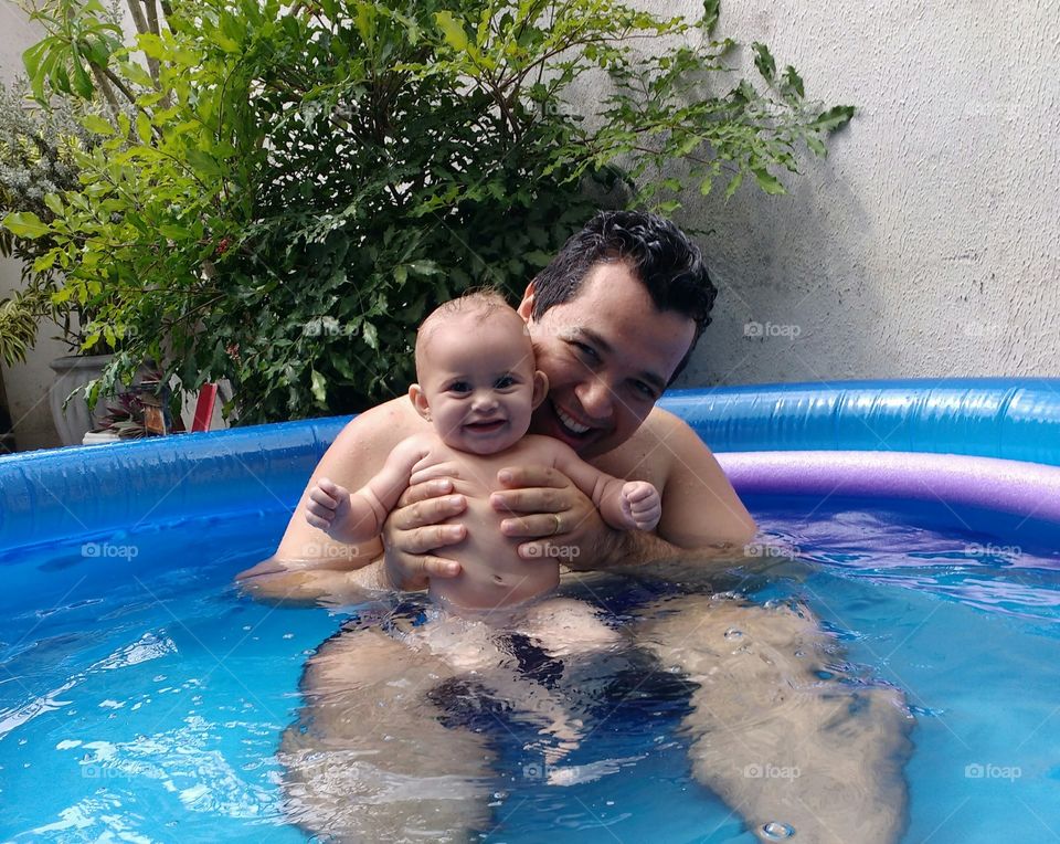 Bebê na piscina infantil com papai